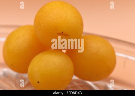 Prugne ciliegia gialle su vassoio rotondo di vetro Foto Stock