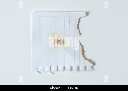 Foglio di carta bianca con centro bruciato e bordi strappati e bruciacchiati Foto Stock