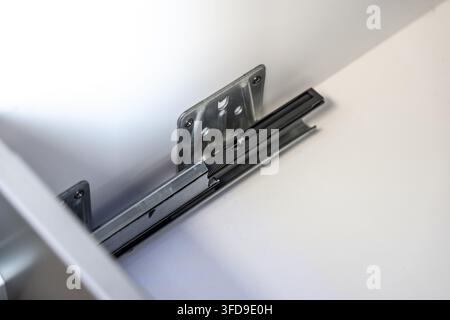 Vista dettagliata di un sistema di guide per cassetti che funziona senza intoppi, evidenziando i suoi componenti interni e il fissaggio sicuro Foto Stock