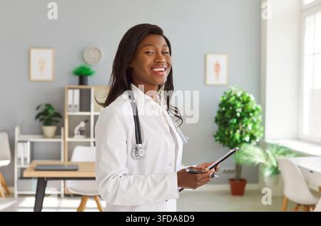Ritratto di una donna medico o infermiera afroamericana sorridente nell'ufficio dell'ospedale Foto Stock