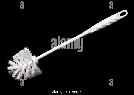 Spazzola per la pulizia del bagno su sfondo nero. Spazzola di plastica bianca isolata su sfondo nero Foto Stock