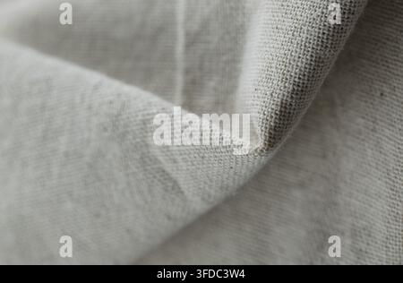 Tessuto di lino naturale che mostra una trama intricata, pieghe sottili e un colore beige neutro Foto Stock