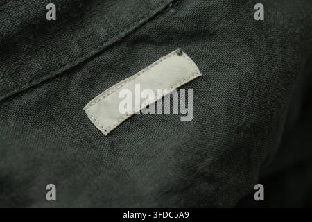 Etichetta tessile vuota su un capo di abbigliamento verde scuro che offre spazio per il branding Foto Stock