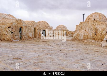 Vista stradale del deserto del luogo di ripresa abbandonato di Mos Espa per Star Wars, con strutture tradizionali a cupola sotto un cielo nuvoloso in Tunisia. Scatto Foto Stock