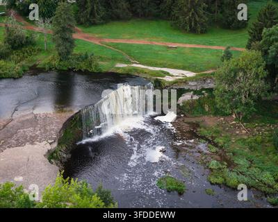 Vista aerea con drone della scenografica cascata di Jagala che si riversa su una scogliera di calcare sul fiume Jagala in Estonia, circondata da foreste rigogliose e Foto Stock