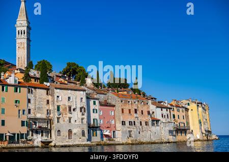 Lungomare della vecchia città di Rovinj e campanile di Santa Eufemia. Lungomare colorato della vecchia città sotto il campanile di Santa Eufemia a Rovinj, Croazia. Foto Stock