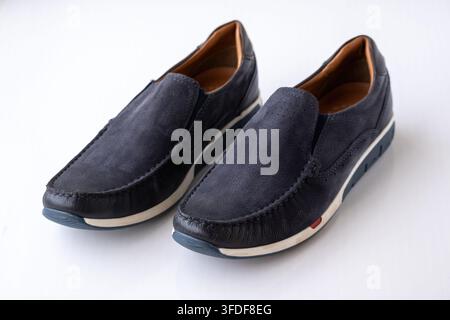 Coppia di mocassini in pelle blu navy eleganti posizionati su sfondo bianco. Calzature casual moderne per la moda maschile, camminata comoda e uso quotidiano Foto Stock