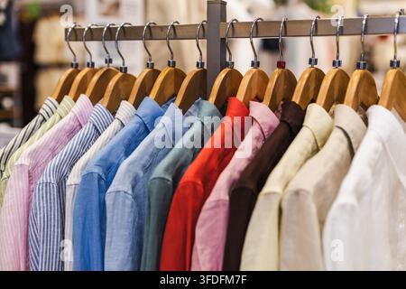 Camicie colorate con colletto su appendiabiti di legno Foto Stock