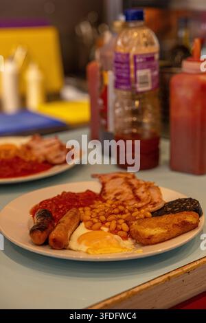 Classica colazione inglese tradizionale completa servita su un piatto in un caffè. Foto Stock