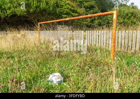 Campo di calcio abbandonato. Erba incolta sul campo di gioco Foto Stock