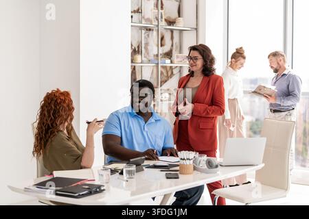 Colleghi che collaborano in una luminosa sala moderna dell'ufficio Foto Stock