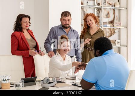 diverso team di dipendenti accoglie la conclusione dell'accordo Foto Stock
