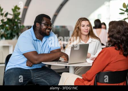 Colleghi diversi che hanno un incontro informale nella lobby dell'ufficio Foto Stock