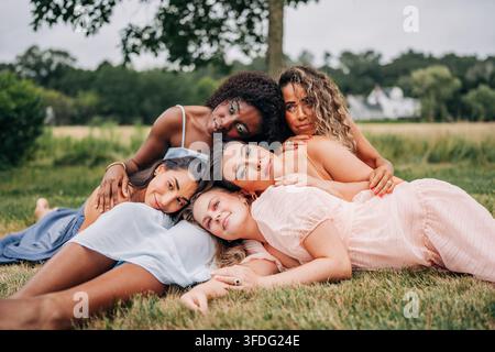 Gruppo diversificato di donne sdraiate insieme sull'erba Foto Stock