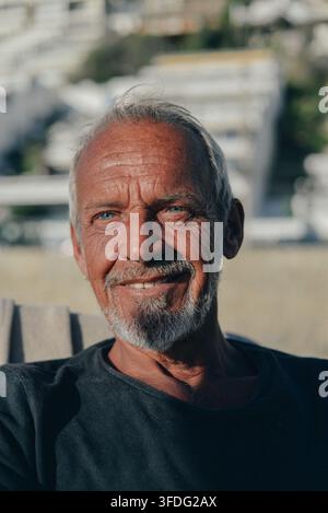 Uomo anziano sorridente con pelle segnata dalle intemperie all'aperto Foto Stock