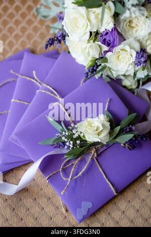 Eleganti inviti di nozze viola con fiori freschi Foto Stock