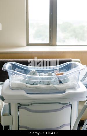Neonato maschio che dorme pacificamente in un lettino da ospedale Foto Stock