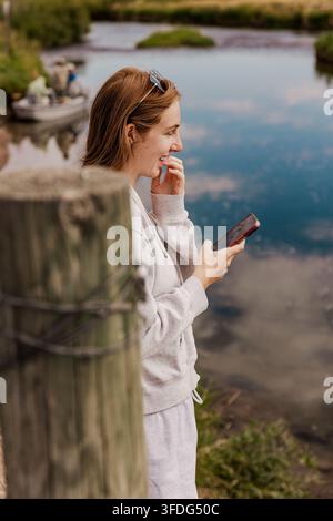 Donna che ride di qualcosa sul suo telefono all'aperto Foto Stock
