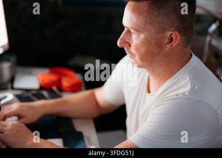 Profilo di un uomo concentrato sullo schermo del computer Foto Stock