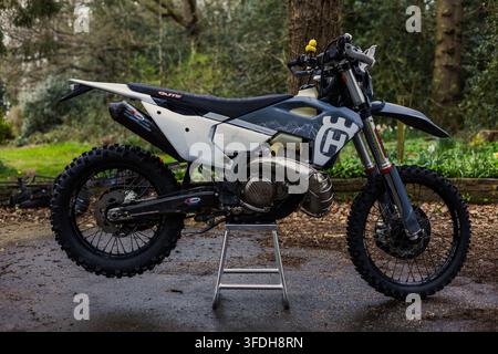 Motocicletta enduro Husqvarna parcheggiata su un supporto in un ambiente boschivo Foto Stock