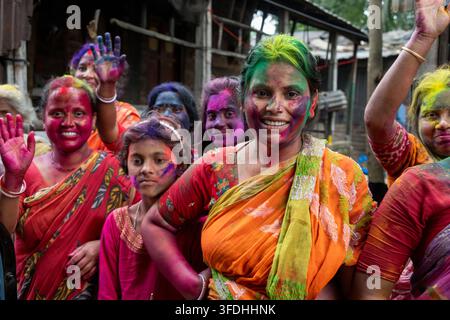 Un gruppo di donne celebra con gioia Holi, la festa indù dei colori, con i volti e i corpi adornati di pigmenti vivaci Foto Stock