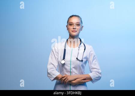 Medico donna che indossa occhiali di sicurezza e stetoscopio Foto Stock