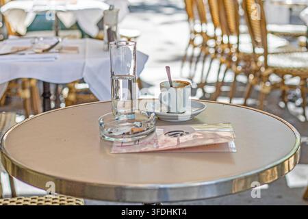 Caffè espresso mattutino lasciato su un tavolo in un caffè privato a Parigi. Buongiorno Foto Stock