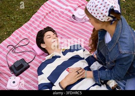 Coppia gioiosa condivide momenti teneri durante un romantico picnic su una coperta Foto Stock