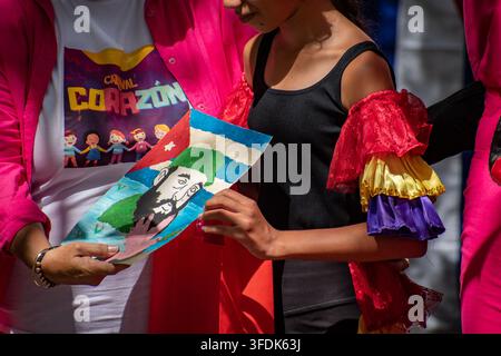 Giovane artista che tiene un disegno di Fidel Castro e della bandiera cubana durante l'evento El Carnavalito il 21 agosto 2026 a Ciego de Ávila, Cuba Foto Stock