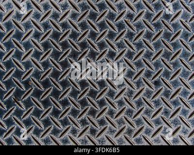 Sfondo texture metallico a piastra diamantata industriale. Primo piano ad angolo alto di un pavimento metallico a piastra diamantata industriale blu invecchiato con texture antiscivolo, Foto Stock