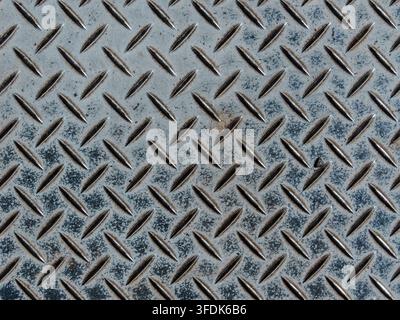 Sfondo texture metallico a piastra diamantata industriale. Primo piano ad angolo alto di un pavimento metallico a piastra diamantata industriale blu invecchiato con texture antiscivolo, Foto Stock