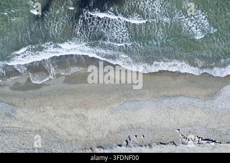 Prospettiva aerea di droni sulla linea costiera e onde schiumose scintillanti, sfondo ideale. Foto Stock