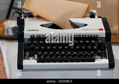 25 luglio 2026 - Selangor, Malesia : Una macchina da scrivere portatile manuale Olympia Traveller de Luxe retrò con tasti neri e carta invecchiata caricata nel rullo Foto Stock
