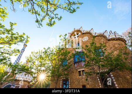 Casa di pan di zenzero su Sunset nel Parco Güell a Barcellona circondata da alberi Foto Stock