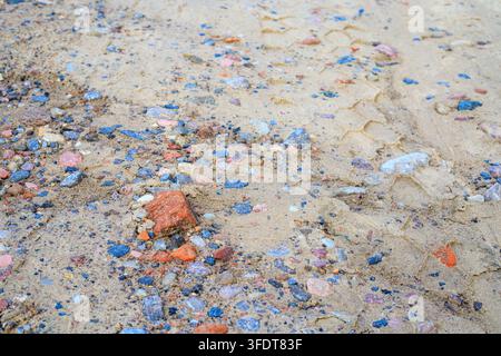 Texture di strada sterrata con ghiaia e sabbia ruvida. Sentiero di terra con piccoli ciottoli di granito rosa, pietre frantumate e dettagli di pista di terra all'aperto Foto Stock