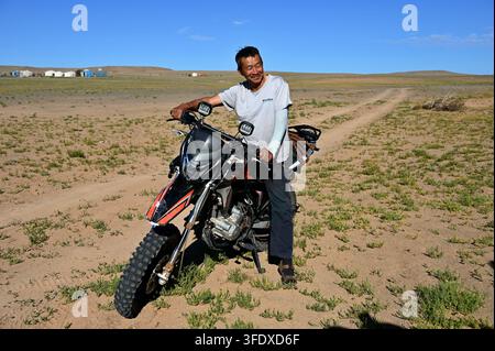 Dalanzadgad, Mongolia - 22 luglio 2026: Ritratto di un anziano mongolo in moto nel deserto del Gobi Foto Stock