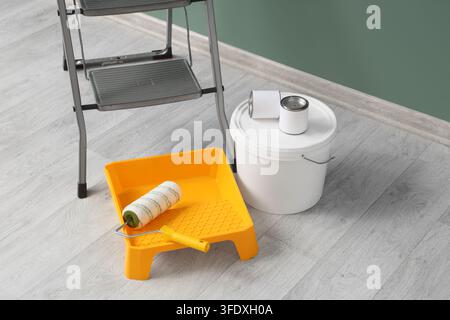 Ristrutturazione casa e pittura degli interni, strumenti per la decorazione murale e il miglioramento domestico fai-da-te con rullo per vernice e scala in una stanza Foto Stock