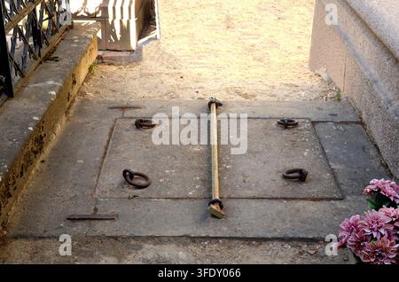 Piatta di pietra con batacchi e barra di ferro come ingresso sotterraneo a un mausoleo familiare nel cimitero di San Gines a Ubeda, Jaen, Spagna. Foto Stock