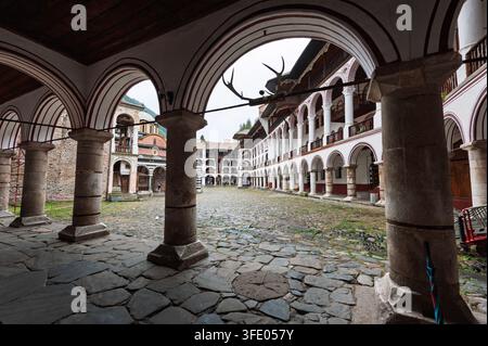 Vista del cortile interno del monastero di Rila, in Bulgaria, dal corridoio esterno ad arco Foto Stock