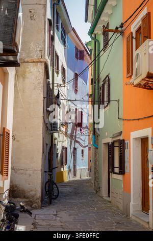 Stretta via colorata con percorso in ciottoli e finestre chiuse nella storica vecchia città costiera di Piran, Slovenia. Foto Stock