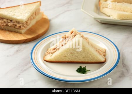 Panino fatto in casa con tonno e maionese affettato su tavolo di marmo bianco Foto Stock
