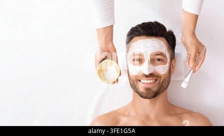 Vista dall'alto di un uomo sorridente con maschera sul bianco Foto Stock
