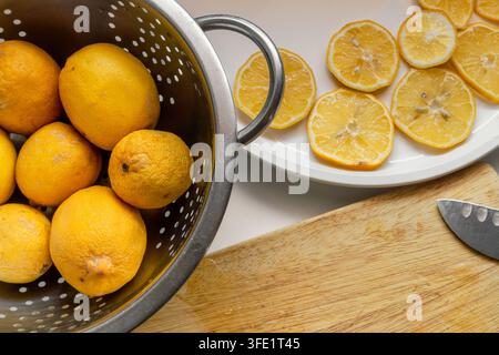 Limoni freschi di giardino affettati per l'essiccazione su un piatto bianco Foto Stock