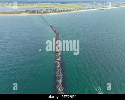 Vista aerea del molo all'estremità sud di Wrightsville Beach che si estende nell'oceano con una piccola barca nelle vicinanze, Wrightsville Beach, Carolina del Nord Foto Stock