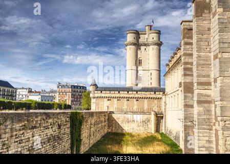 Il mastio storico e le mura fortificate dello Château de Vincennes sotto un cielo blu nuvoloso, Vincennes, Val-de-Marne, Île-de-France, Francia. Foto Stock