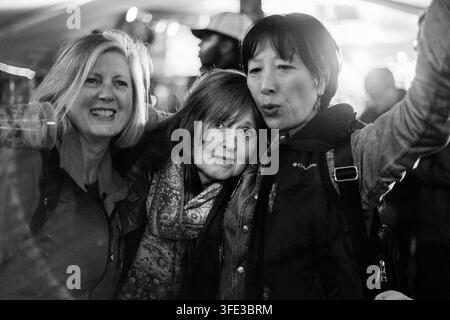 TRE AMICHE DONNE CHE SI ABBRACCIANO A UN FESTIVAL, REPORTAGE, GREEN MAN FESTIVAL 2017, BRECON, GALLES, REGNO UNITO, 2017: Una foto in bianco e nero in primo piano mostra tre amiche sorridenti di mezza età che si abbracciano in un momento di felicità durante un evento notturno. Foto: Rob Watkins. INFO: Il Green Man Festival è iniziato nel 2003 in Galles. Si tiene ogni anno nei Brecon Beacons il terzo fine settimana di agosto e celebra musica alternativa, arte, letteratura, scienza e cultura familiare in uno splendido paesaggio montano. Foto Stock