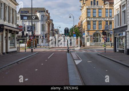 Haarlem, Paesi Bassi - 16 agosto 2026: pista ciclabile in asfalto rosso vuota e segnali stradali a un incrocio cittadino di Haarlem. Foto Stock