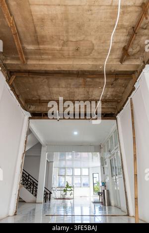 Corridoio interno in ristrutturazione con soffitto in cemento a vista e supporti in legno Foto Stock