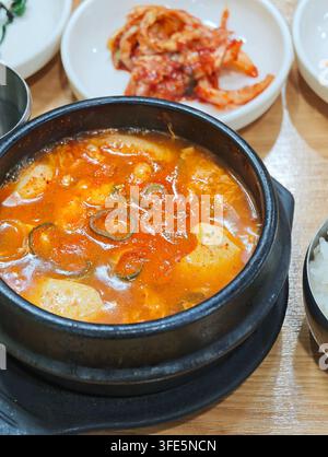 Sundubu jjigae coreano piccante servito con kimchi e riso, un pasto tradizionale in Corea. Foto Stock