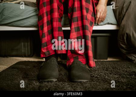 Sezione bassa di un uomo seduto sul letto che si sveglia a casa Foto Stock